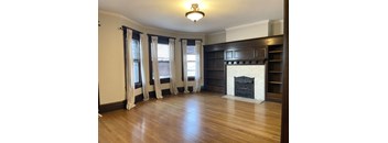 A room with a fireplace and wooden floors.