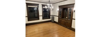 A room with wooden floors and a chandelier.