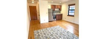 A kitchen with a refrigerator, oven, and microwave.