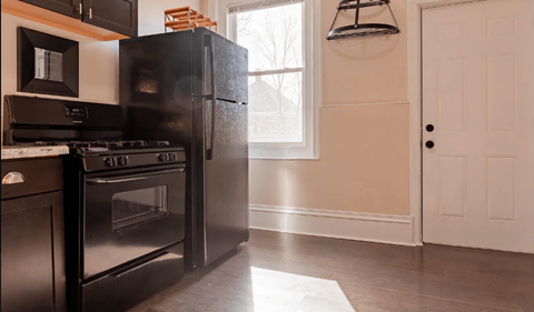 A black stove and oven in a kitchen with a white door.