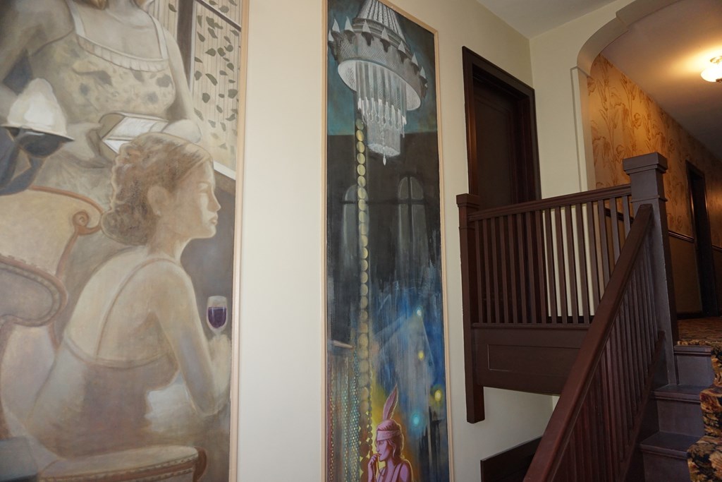 A painting of a woman is on the wall.