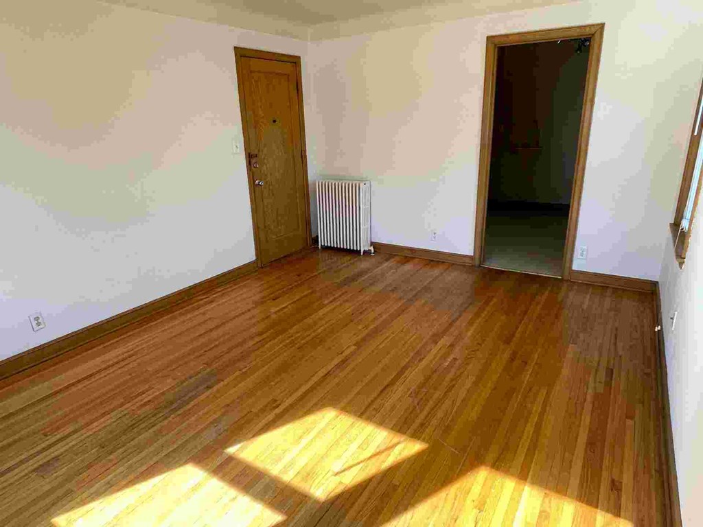 A room with wooden floors and two doors.