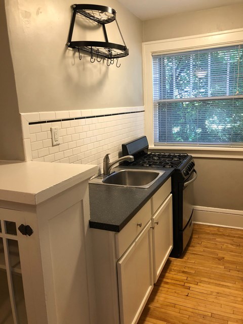 A kitchen with a black stove top oven and a black dishwasher.