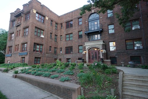 A large red brick building with a green lawn in front.