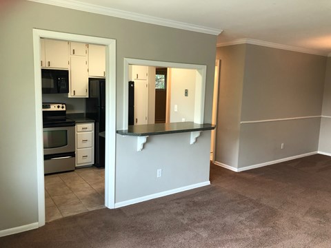 A kitchen with a white counter and a white fridge.