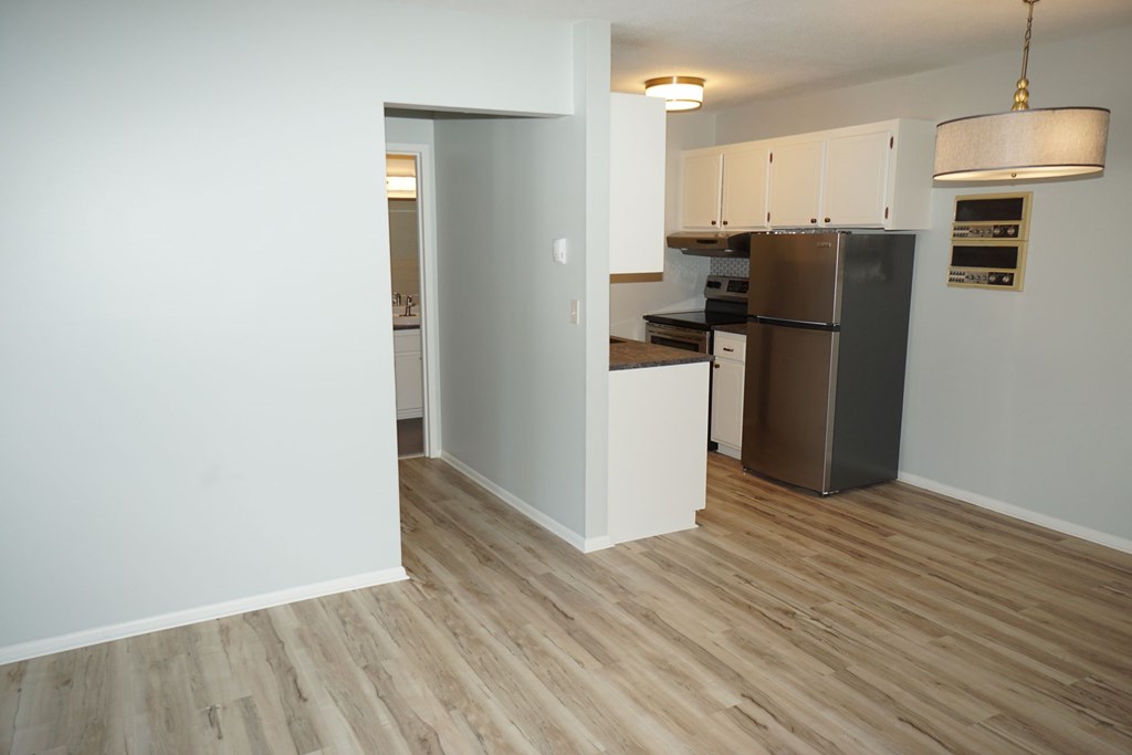 A kitchen with a refrigerator, oven, and cabinets.