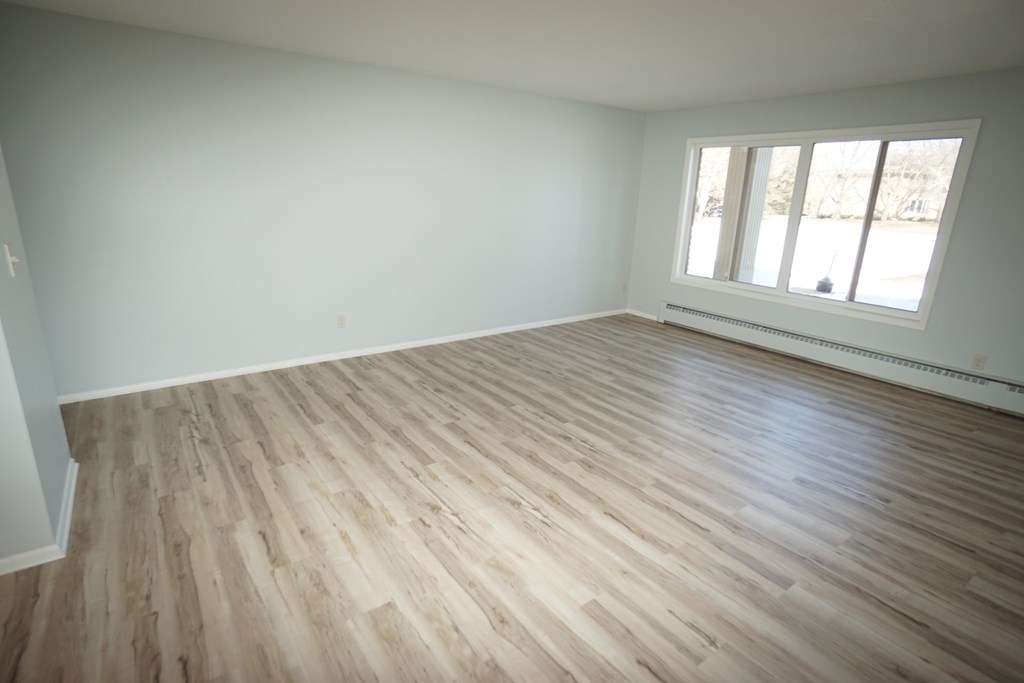 A room with wooden flooring and a window.