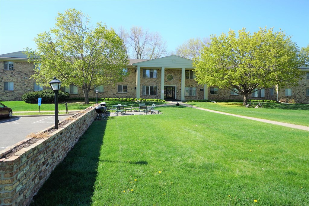 A large house with a green lawn in front.