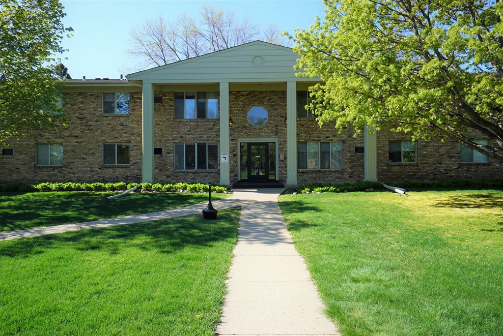A building with a green lawn in front.
