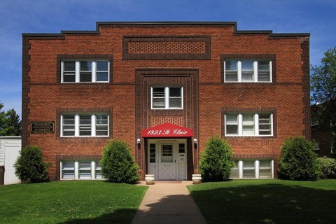 A red brick building with a white door and windows.