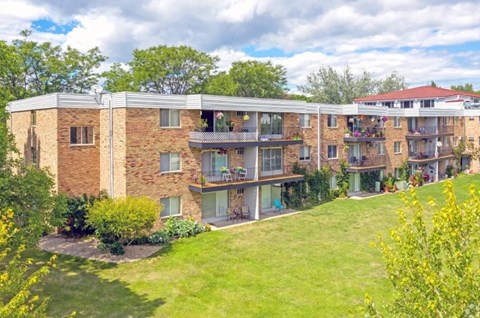 A large apartment complex with a green lawn in front.
