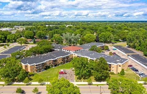 A large building surrounded by trees and a parking lot.