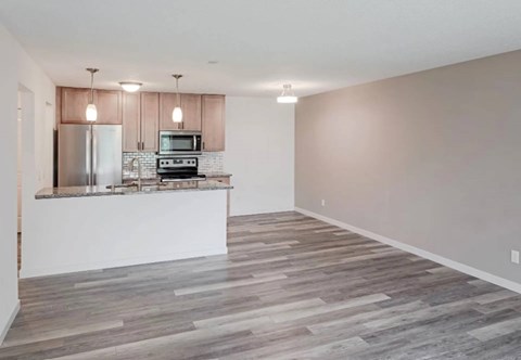 A kitchen with a refrigerator, microwave, and oven.