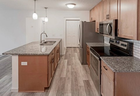 A kitchen with wooden cabinets and a granite countertop.