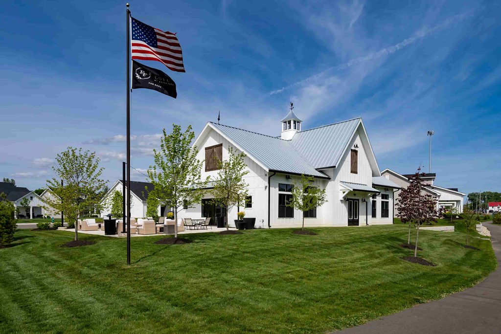 A white building with a black flagpole in front of it.