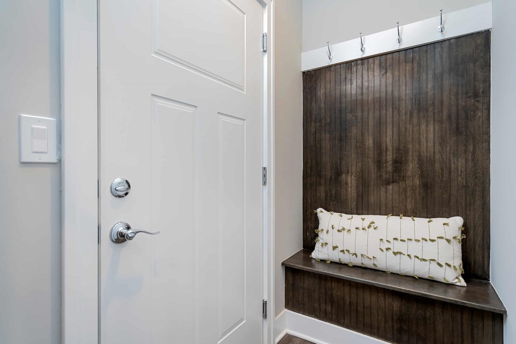 A white door with a silver handle and a white pillow with black lines on it.