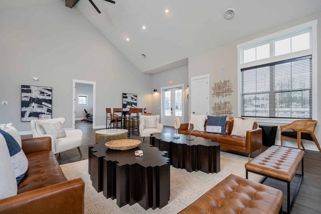 A living room with a black coffee table and brown leather chairs.