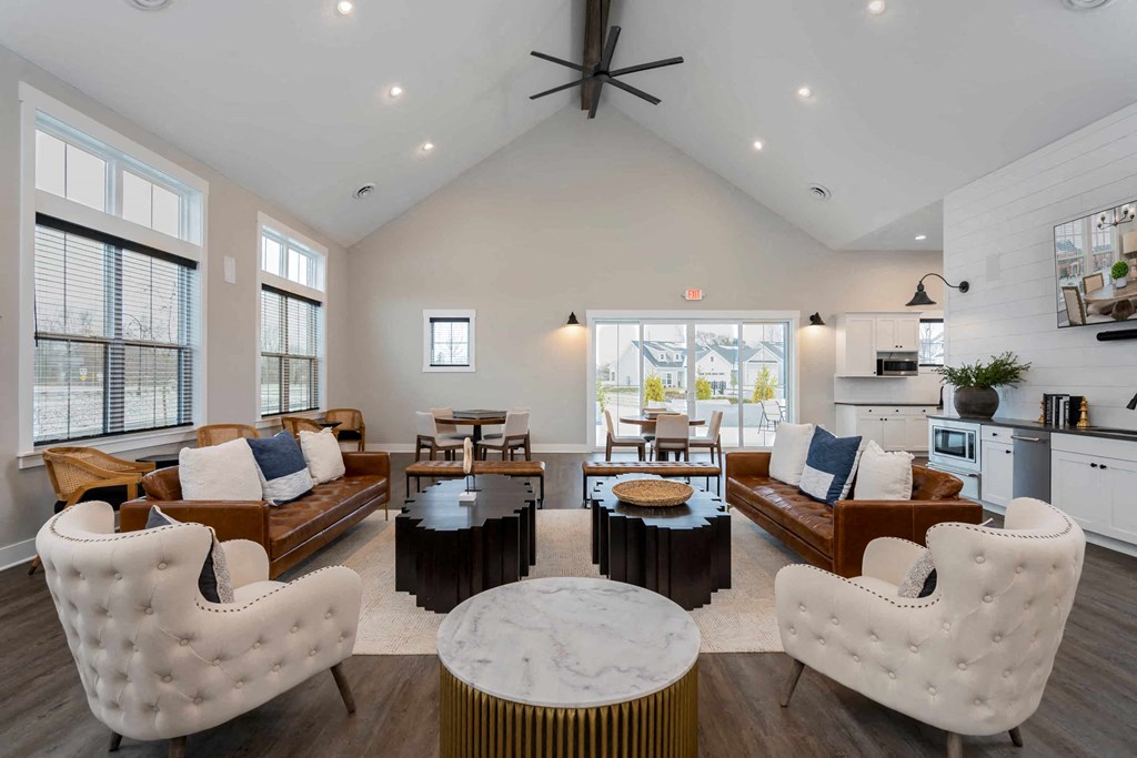 A modern living room with white furniture and a large window.
