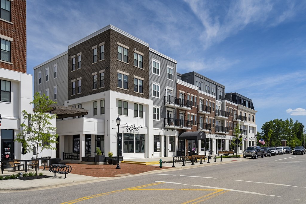 A street view of a row of buildings with a clear blue sky above.