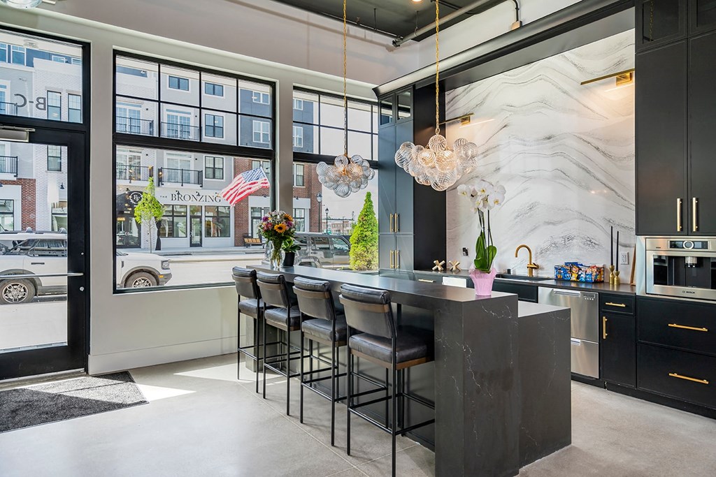 A kitchen with a marble backsplash and a bar area.