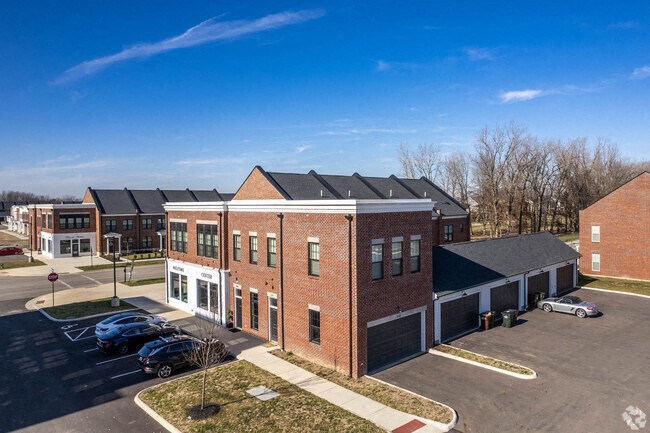 A parking lot in front of a brick building with a clear blue sky.
