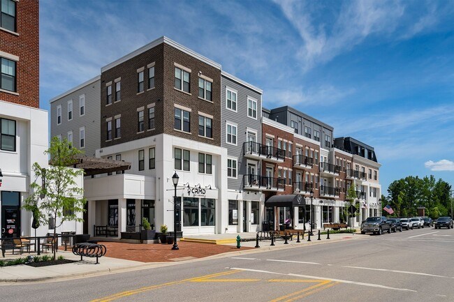 A street view of a row of buildings with a clear blue sky above.