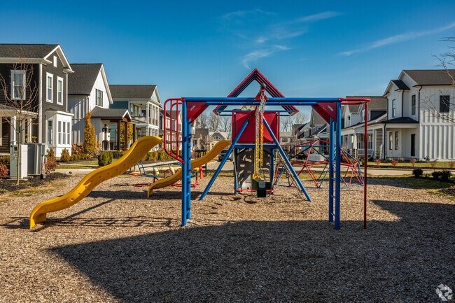 A playground with a yellow slide and a red and blue structure.