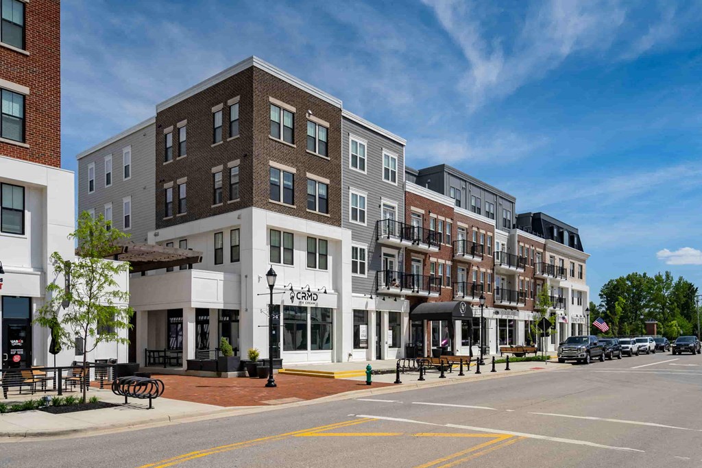 A street view of a row of buildings with a clear blue sky above.