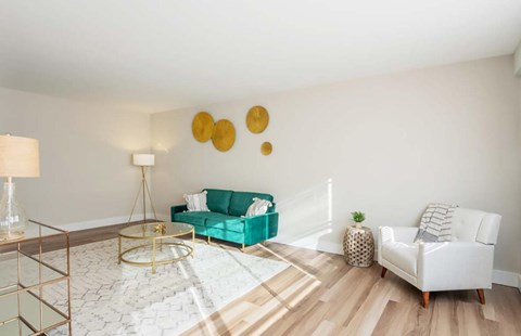 A living room with a green couch and a white chair.