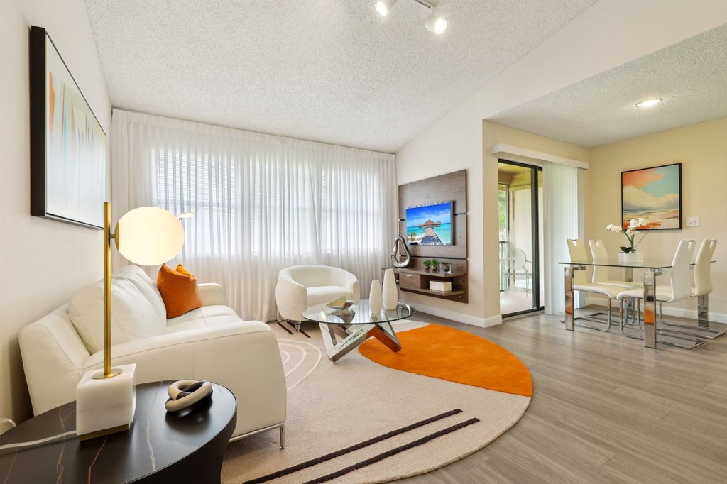 A modern living room with a white sofa and a glass coffee table.