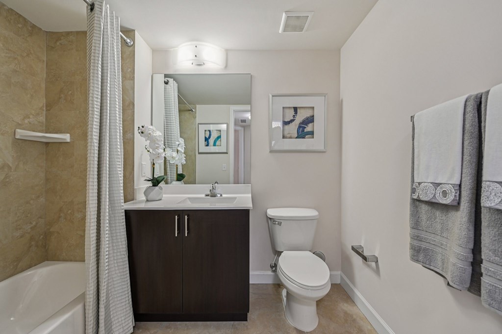 A bathroom with a toilet, sink, and bathtub.
