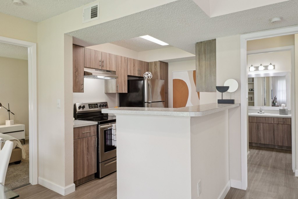 A kitchen with a white island and wooden cabinets.