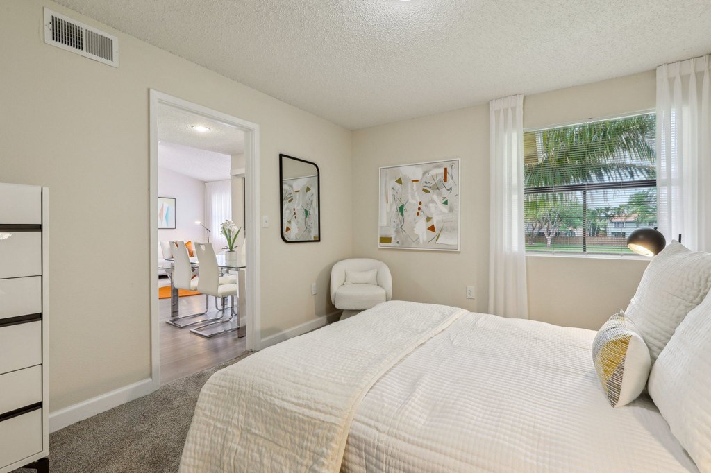 A bedroom with a large bed and a painting on the wall.