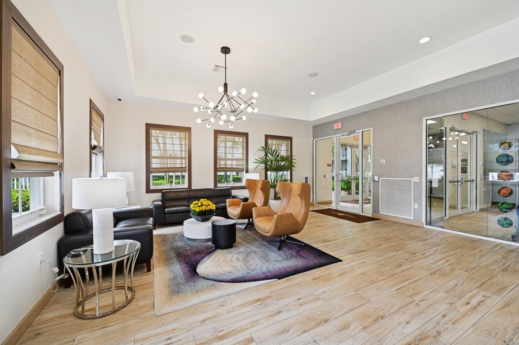 A modern living room with a wooden floor and a glass chandelier.