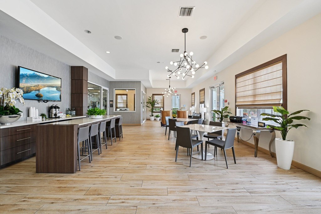 A modern kitchen with a bar area and a dining table.