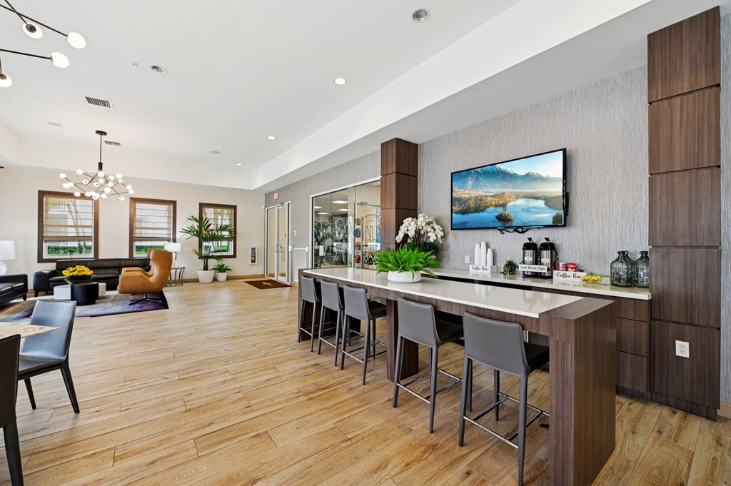 A modern kitchen with a bar and a TV mounted on the wall.