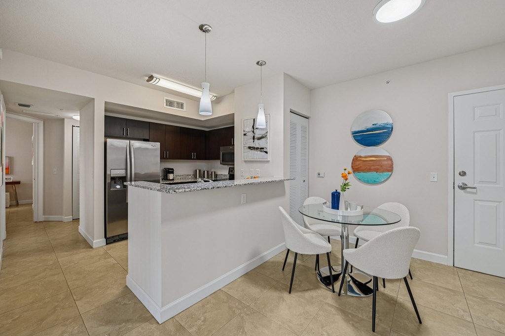 A kitchen with a table and chairs in the middle of the room.