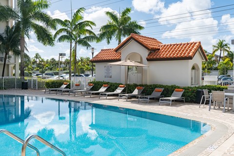 A pool with a small building behind it.