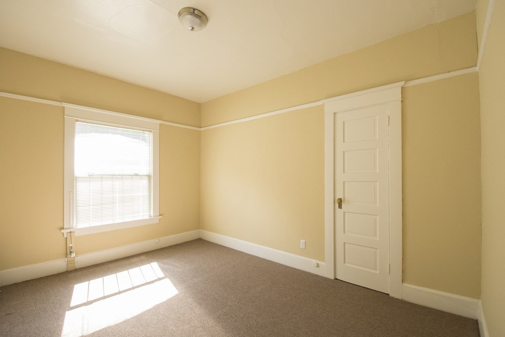 an empty room with a door and a window