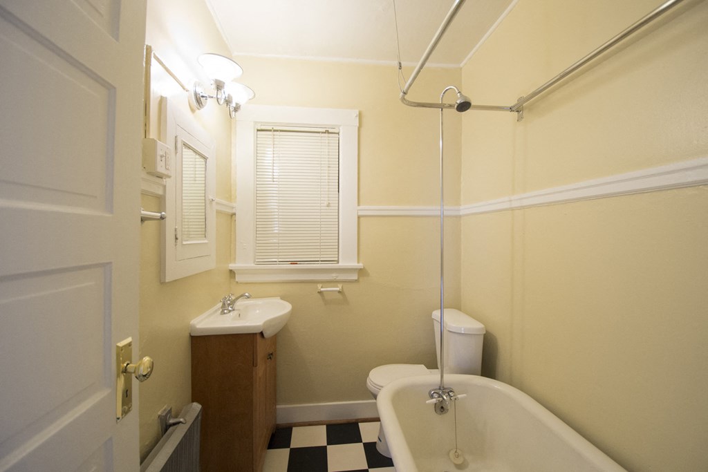a bathroom with a white tub and a sink and a toilet