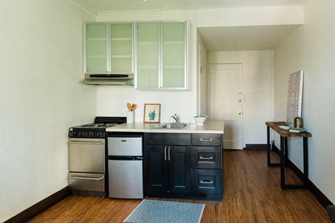 a kitchen with black cabinets and a stove and a sink