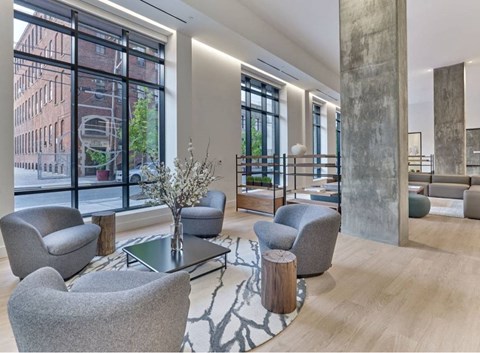A modern living room with grey chairs and a coffee table.