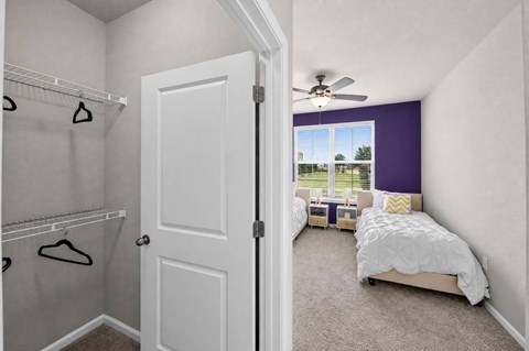 A bedroom with a white bed and a purple accent wall.