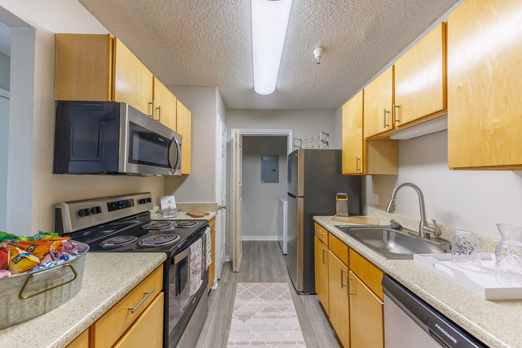 A kitchen with wooden cabinets and a black microwave.