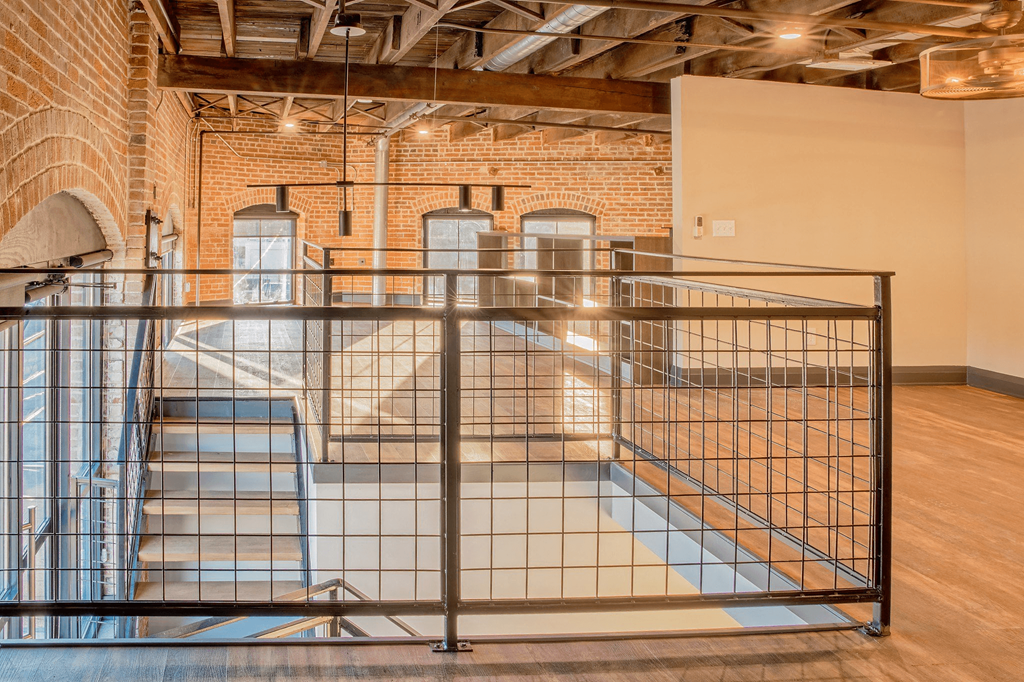 A room with a brick wall and a metal railing.