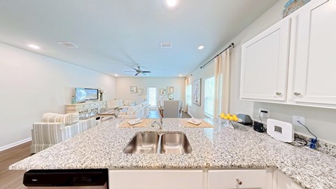 A kitchen with a granite countertop and a fan on the ceiling.