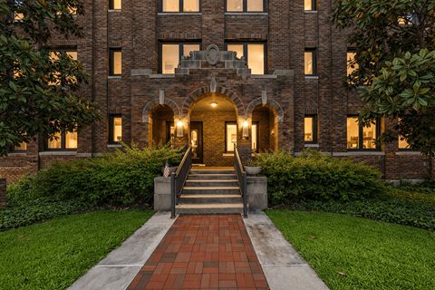 A large building with a brick facade and a flag on the front.