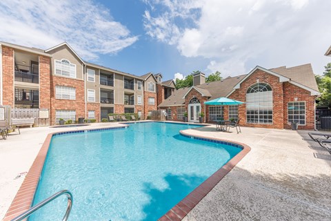 A swimming pool in front of a brick building.