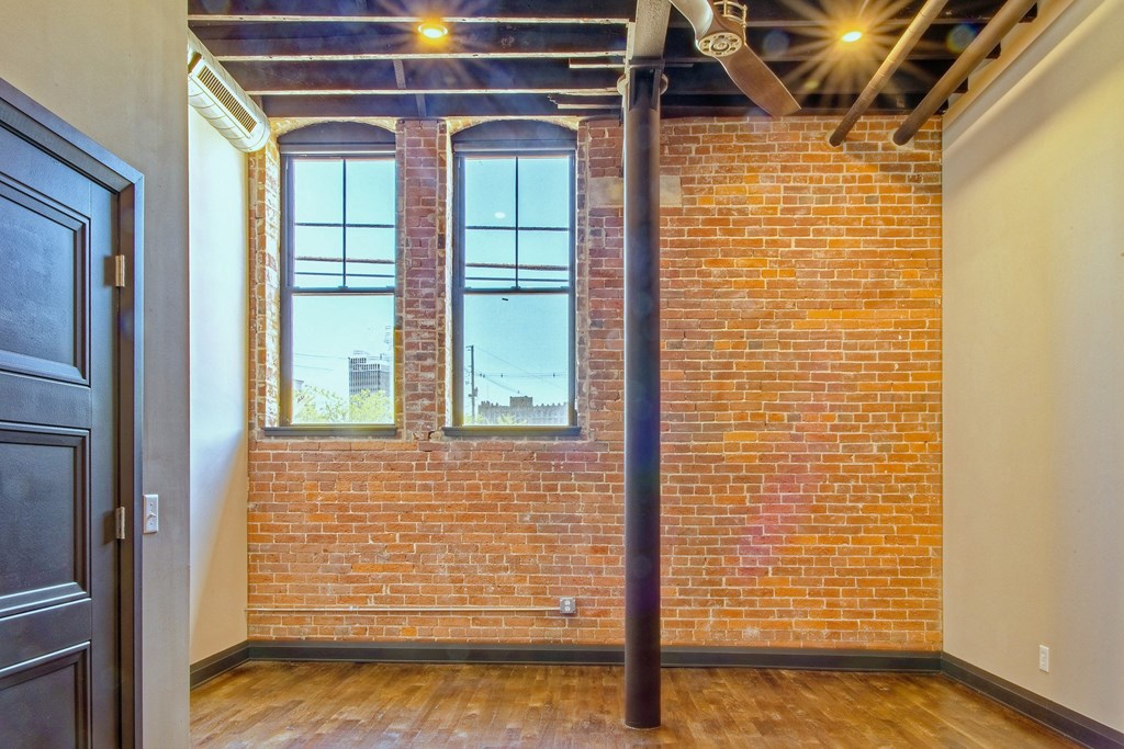 A room with a brick wall and a window.