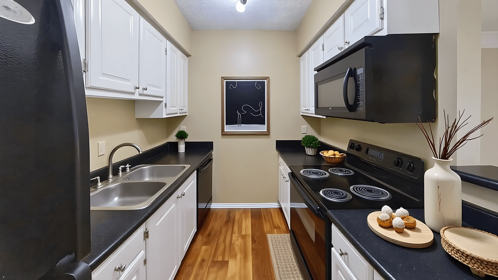 A kitchen with black appliances and white cabinets.